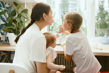 Image showing The happy smiling caucasian family in the kitchen preparing breakfast