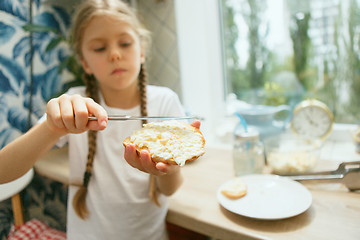 Image showing Beautiful girl in her kitchen in the morning preparing breakfast