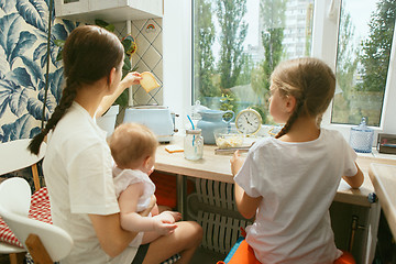 Image showing The happy smiling caucasian family in the kitchen preparing breakfast
