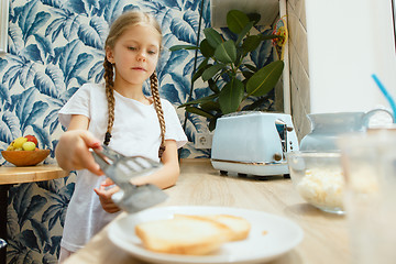 Image showing Beautiful girl in her kitchen in the morning preparing breakfast