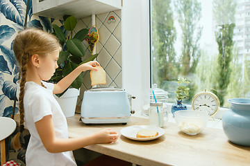 Image showing Beautiful girl in her kitchen in the morning preparing breakfast