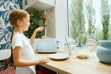 Image showing Beautiful girl in her kitchen in the morning preparing breakfast