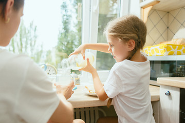 Image showing The happy smiling caucasian family in the kitchen preparing breakfast