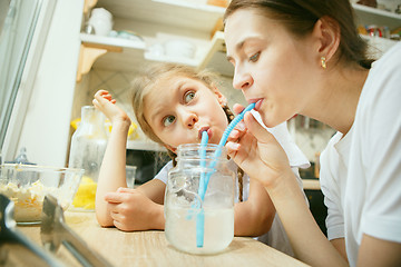 Image showing The happy smiling caucasian family in the kitchen preparing breakfast