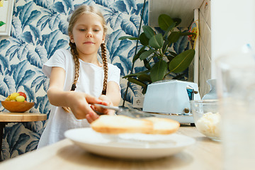 Image showing Beautiful girl in her kitchen in the morning preparing breakfast