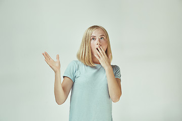 Image showing Beautiful woman looking suprised isolated on gray