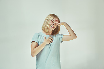 Image showing The happy freckled woman standing and smiling against gray background.