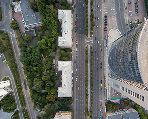 Image showing Top view of a modern business center building with a high-speed highway near it. Photo from the drone.