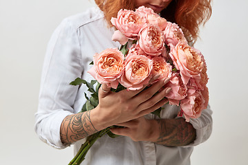 Image showing the girl is holding a bouquet of pink roses