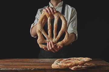 Image showing Baker\'s hands hold fougas bread