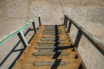 Image showing Long wooden staircase going down