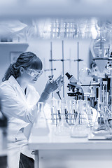 Image showing Young scientist pipetting in life science laboratory.