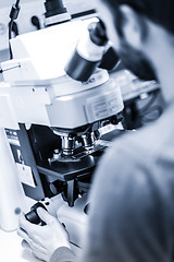 Image showing Scientist microscoping on fluorescent microscope.