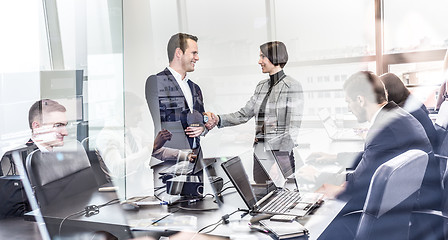 Image showing Business people shaking hands in moder corporate office.