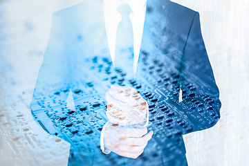 Image showing Businessman wearing fashionable classic navy blue suit against pc motherboard chip photo layer