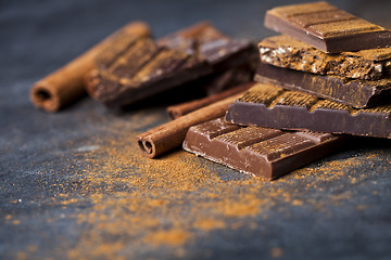 Image showing Chocolate stacked on black background. Chocolate bar pieces heap