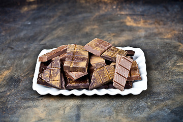 Image showing Chocolate bar pieces heap witn cinnamon powder on white ceramic 