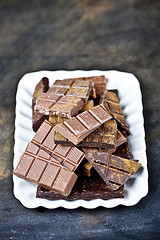 Image showing Chocolate bar pieces heap witn cinnamon powder on white ceramic 