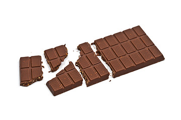 Image showing Broken milk chocolate bar with hazelnuts isolated on white.