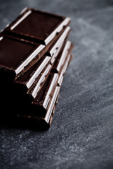 Image showing Dark chocolate bar pieces closeup. Sweet food photo concept. 