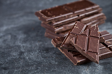 Image showing  Chunks of broken chocolate stacked on grey background.