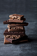 Image showing Chunks of broken chocolate stacked on black board.