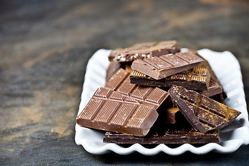 Image showing Chocolate bars pieces heap witn cinnamon powder on white ceramic