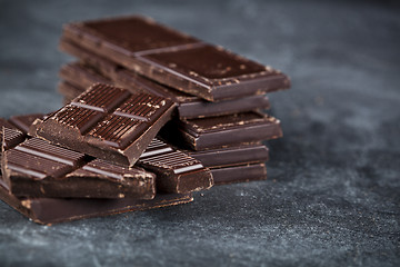 Image showing Dark chocolate bar pieces closeup. Sweet food photo concept. 