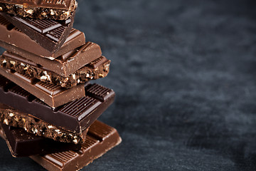 Image showing Chocolate bar pieces closeup. Sweet food photo concept with copy