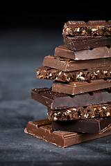 Image showing Chocolate bar pieces closeup. Sweet food photo concept with copy