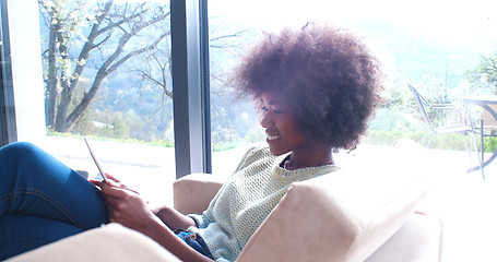 Image showing african american woman at home using digital tablet