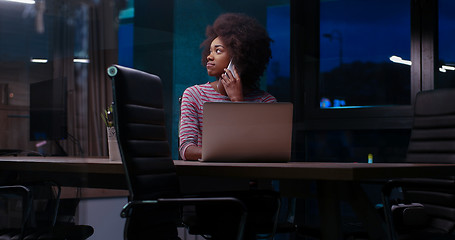 Image showing black businesswoman using a laptop in night startup office