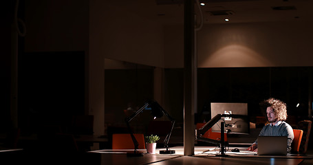 Image showing man working on computer in dark office