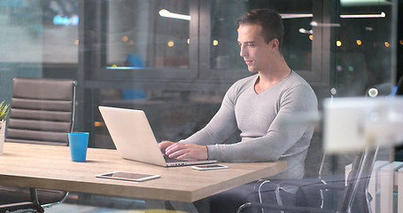 Image showing man working on laptop in dark office