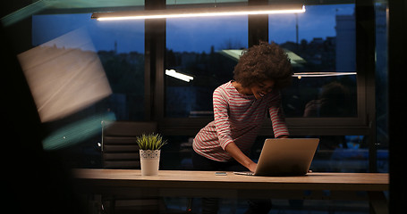 Image showing black businesswoman using a laptop in night startup office