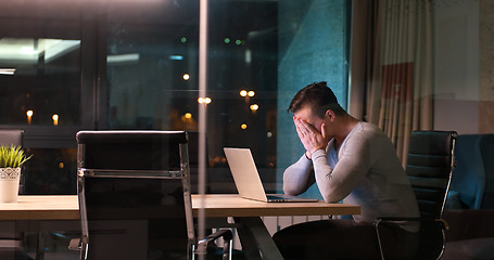 Image showing man working on laptop in dark office