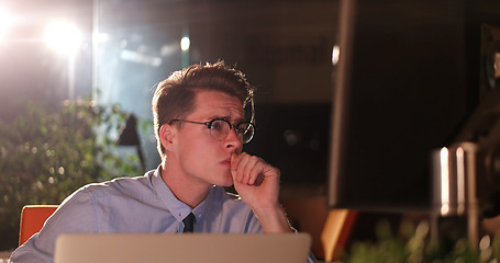 Image showing man working on computer in dark office