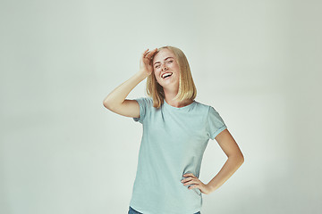 Image showing The happy freckled woman standing and smiling against gray background.