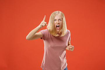 Image showing Beautiful female half-length portrait isolated on red studio backgroud. The young emotional surprised woman