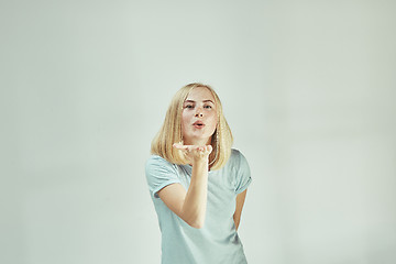 Image showing Portrait of attractive cute girl with kiss isolated over gray background