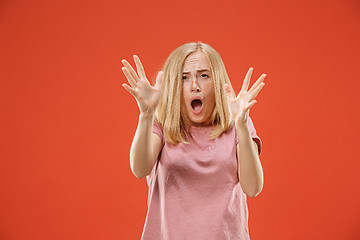 Image showing Portrait of the scared woman on red