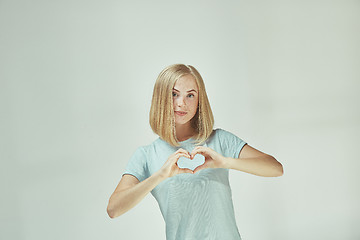 Image showing Portrait of attractive cute girl with kiss isolated over gray background