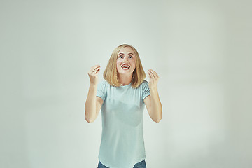 Image showing Beautiful female half-length portrait isolated on gray studio backgroud. The young emotional surprised woman