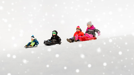 Image showing kids sliding on sleds down snow hill in winter