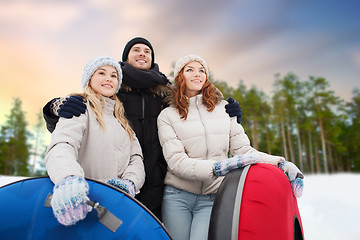 Image showing happy friends with snow tubes outdoors in winter