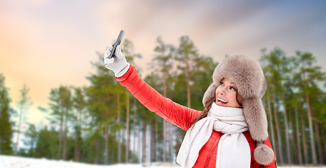 Image showing happy woman taking selfie over winter forest