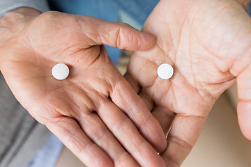 Image showing close up of senior couple hands with pills