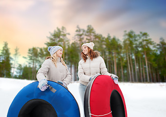 Image showing happy teenage girls with snow tubes in winter