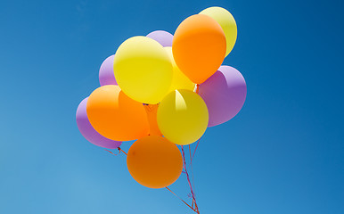 Image showing close up of colorful helium balloons in blue sky