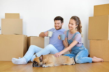 Image showing happy couple with boxes and dog moving to new home